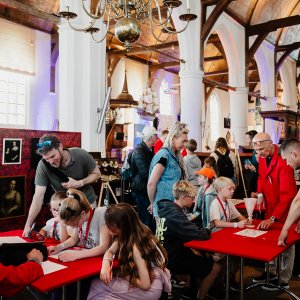 Kinderen zitten aan tafels in een kerk