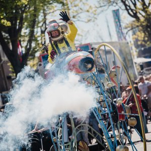 Een astronaut met een stomende wagen rijdt door de stad.
